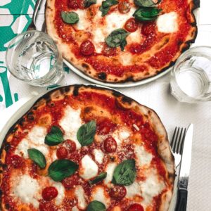 Two delicious pizzas topped with mozzarella and basil, perfect for a tasty meal.